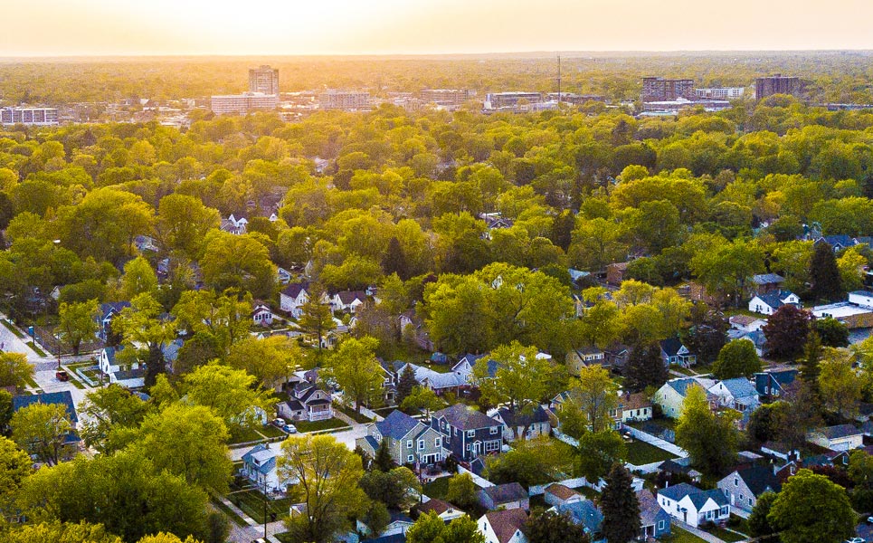 Aerial photo of sunset over trees in a neighborhood